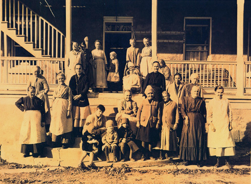 Men and women gather on the front steps of a building