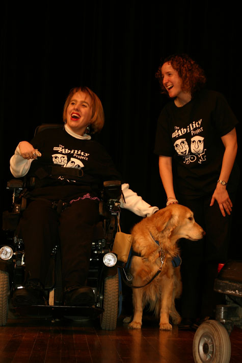 A woman who uses a wheelchair is accompanied by her service dog.
